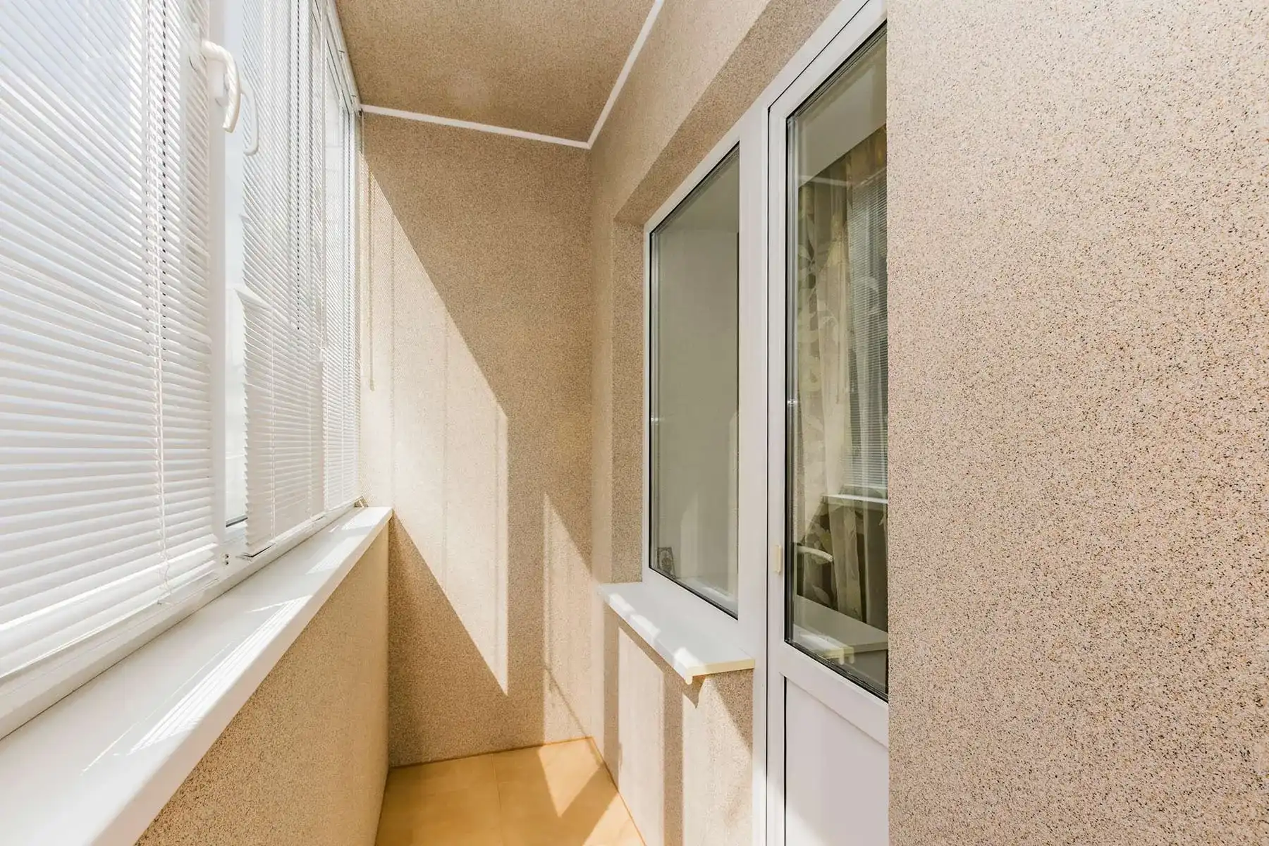 Стены и потолок на балконе покрыты декоративной штукатуркой